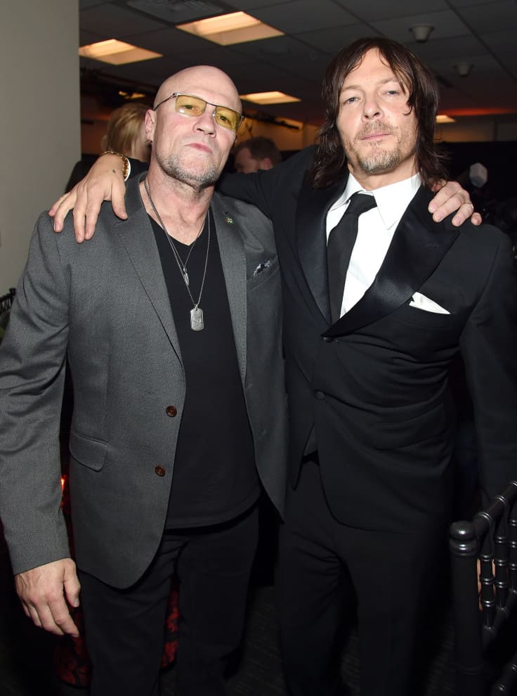 Michael Rooker and Norman Reedus wearing suits and hug